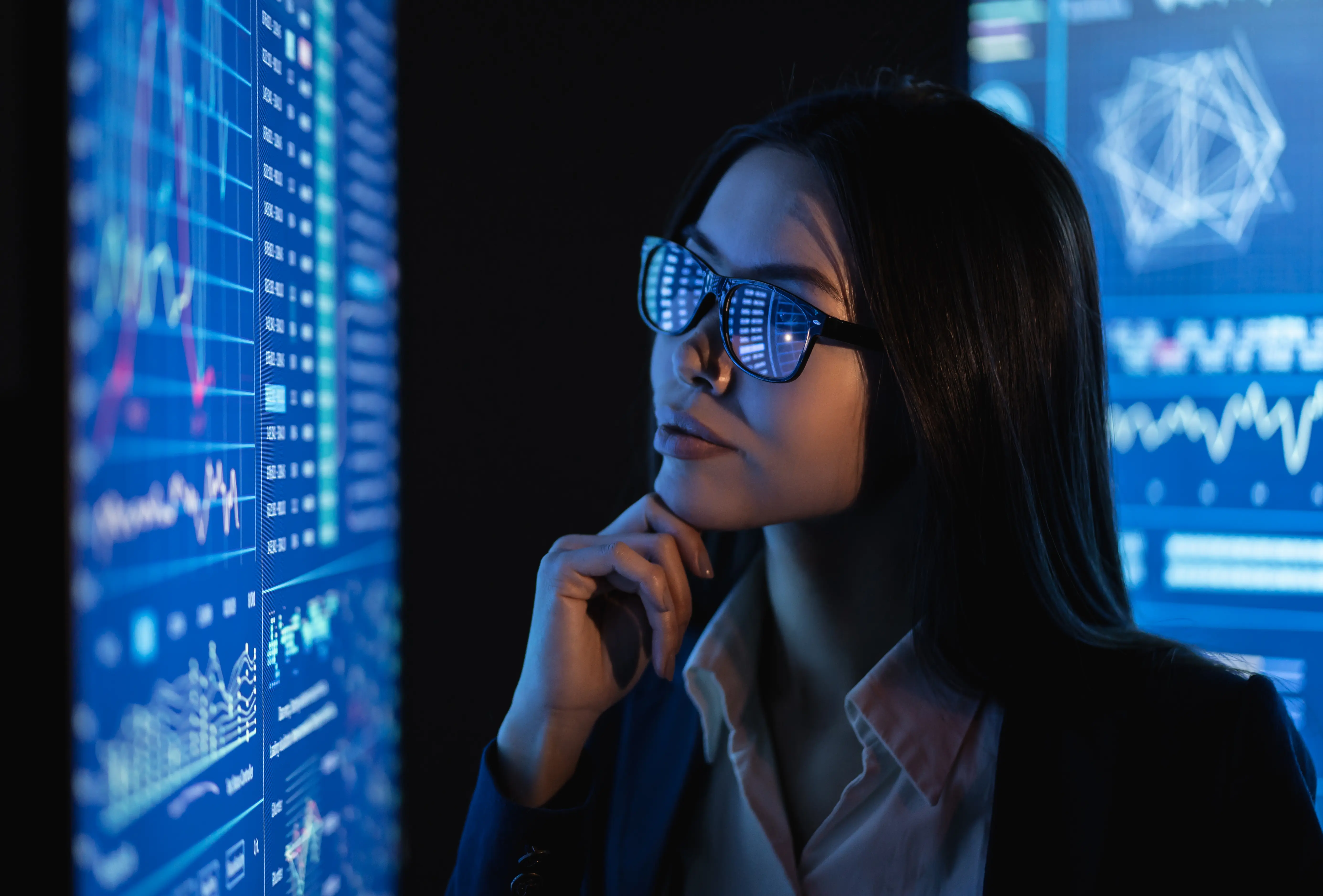 A business professional analyzing complex data dashboards on multiple digital screens, reflecting strategic thinking, performance monitoring, and data-driven leadership.